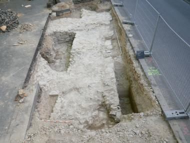 In dem kleinen Schnitt ist die Mächtigkeit der alten Stadtmauer gut zu dokumentieren. Links davon ist das runde Fundament des Turms zu erken-nen.<br>Foto: EggensteinExca/Ralf Mahytka