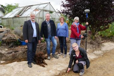 Freuen sich darüber, die älteste Kirche Vlothos entdeckt zu haben (v.l.n.r.): Pfarrer Christoph Beyer, LWL-Archäologe Dr. Sven Spiong, Grundstücksbesitzerin Anita Weckesser, LWL-Grabungstechnikerin Ute Kroprivc und Grabungshelferin Jessica Lücke (kniend).<br>Foto: LWL/J. Schubert