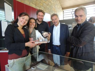 Freuen sich über die Eröffnung der Ausstellung (v.l.n.r.): Sarah Coesfeld, Wissenschaftliche Volontärinin der Kaiserpfalz, die Paderborner Stadtarchäologin Dr. Sveva Gai, Till Lodemann, Wissenschaftlicher Volontär der Stadtarchäologie, der Stellvertretende Bürgermeiste Dietrich Honervogt und Museumsleiter Dr. Martin Kroker. Viele der Exponate stammen aus mittelalterlichen Grubenhäusern (Modell).<br>Foto: LWL/N.Wolpert