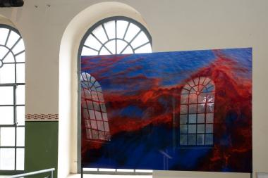 Die Fenster der Maschinenhalle der Zeche Hannover spiegeln sich auf einem Bild, das im Meer treibendes Öl aus dem Leck der Ölplattform "Deepwater Horizon" zeigt.<br>Foto: LWL/Hudemann