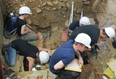 Vor dem großen Westprofil dringen die Studierenden auf dem Vorplatz der Blätterhöhle sicher und präzise in immer tiefere Schichten vor.<br>Foto: LWL/W. Heuschen