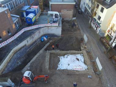 Luftbild der Grabungsfläche. Im Vordergrund sind die Grundmauern eines frühneuzeitlichen Stadthauses und die Terrassenmauer des ehemaligen Brenkenhofs zu sehen.<br>Foto: Eggenstein Exca/R. Gündchen