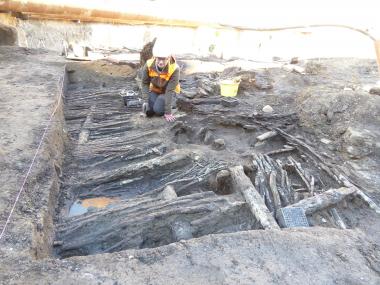 Archäologin Sarah Gonschorek legt die Hauswand des 13./14. Jahrhunderts zur weiteren Untersuchung und Dokumentation sorgfältig frei.<br>Foto: LWL/Sven Spiong