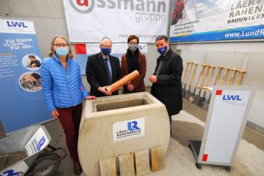 Eine Kupfer-Kapsel gefüllt mit aktuellen Zeitungen, Münzen, Bauplänen auf einem USB-Stick und einem Hausaufgabenheft für Schüler legten (v.l.) Schulleiterin Magdalene Beermann, LWL-Direktor Matthias Löb, LWL-Schuldezernentin Birgit Westers und BLB-Betriebsleiter Matthias Gundler in den Grundstein für das neue Gebäude der Martin-Luther-King-Schule hinein.<br>Foto: LWL/Fechtner