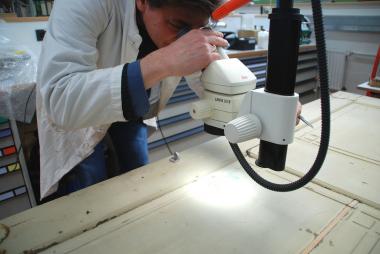 Restaurator Wolfram Bangen untersucht die Farbbefunde auf einer Zimmertür des Hauses Stöcker.<br>Foto: LWL