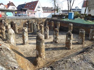 Wegen des hohen Grundwasserstandes mussten zunächst Betonsäulen als Fundamentierung für den Neubau in den Boden eingebracht werden. Der Aushub erfolgte dann nach und nach um diese Säulen herum bis auf ca. 2,50 m Tiefe.<br>Foto: LWL-Archäologie für Westfalen/J. Hallenkamp-Lumpe