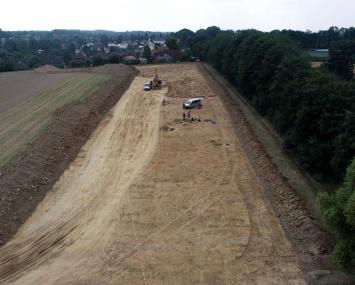Drohnenfoto der Fundfläche im Norden von Frömern (Hintergrund) unmittelbar neben der Eisenbahnstrecke (rechts).<br>Foto: LWL-Archäologie/D. Riemenschneider
