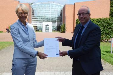 Regierungspräsidentin Dorothee Feller übergibt den Förderbescheid an LWL-Direktor Matthias Löb.<br>Foto: Bezirksregierung Münster