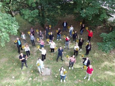 Die frisch gebackenen Gesundheits- und Krankenpfleger:innen zusammen mit ihren Ausbilder:innen und den Dortmunder Mitschüler:innen im Garten der LWL-Akademie für Gesundheits- und Pflegeberufe in Dortmund.&lt;br&gt;Foto: LWL/Herstell 