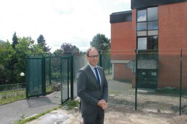 Jan Hendrik Unger, kaufmännischer Direktor der Einrichtungen Marsberg des Landschaftsverbands Westfalen-Lippe (LWL), vor dem für das LWL-Therapiezentrum umgebauten Gebäude mit dem Sicherheitszaun an der Bredelarer Straße.&lt;br&gt;Foto: LWL/ Hollwedel 