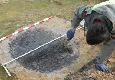 Eine mittelalterliche Pfostengrube wird untersucht, die mit viel Holzkohle vermengte Verfüllung könnte auf ein Brandereignis zurückgehen. <br>Foto: Fa. Eggenstein Exca