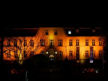 Das Verwaltungsgebäude in Lippstadt-Eickelborn erstrahlt am Donnerstagabend in kräftigem Orange.&lt;br&gt; Foto: LWL 