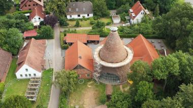 Luftbildaufnahme der Glashütte Gernheim mit dem Glasturm, der wegen der Sanierung derzeit eingerüstet ist.<br>Foto: LWL 