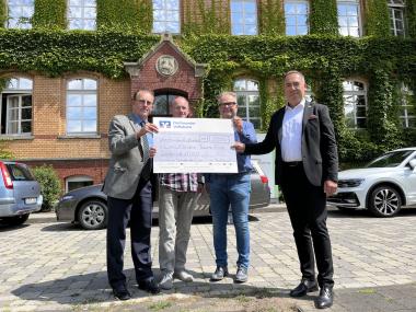 Dr. Thomas Graefenstein (l.) und René Thiemann (r.) vom Lions Club Dortmund überreichen den Spendenscheck an Volker Hustert (2.v.l.) und Michael Wischeler von der LWL-Klinik Dortmund.<br>Foto: LWL/Bothe