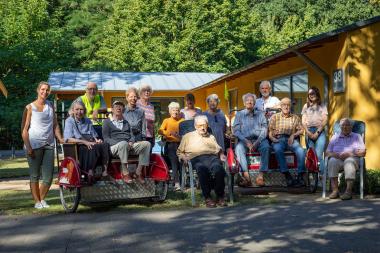Gruppenfoto mit Rikschas vor dem Gebäude der Tagespflege auf dem Gelände des LWL-Klinikums Gütersloh.<br>Foto: LWL-Klinikum Gütersloh/Eckhard Sallermann