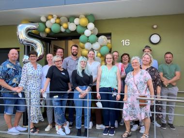Das Team des LWL-Wohnhauses am Phönixsee am festlich geschmückten Hauseingang. In der Mitte steht Einrichtungsleiterin Svenja Magiera (weiße Bluse).<br>Foto: LWL/Herstell