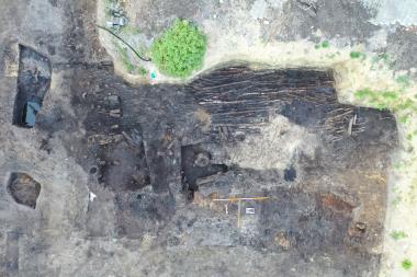 Das Drohnenfoto zeigt die flächige Lage von Ästen und dünnen Stämmen, die den torfigen Untergrund begehbar machen sollte.<br>Foto: Melisch Archäologie KG