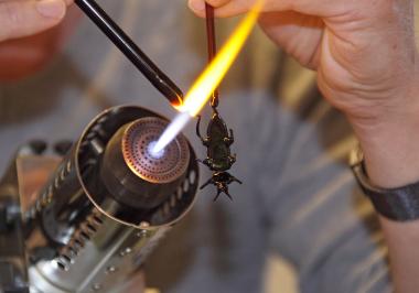 Glasbläser Falk Bauer fertigt vor den Augen der Besucher:innen Insekten "vor der Lampe".<br>Foto: LWL / Holtappels