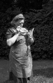 "Kitzken" meint nicht das junge Reh, das die Frau hier wahrscheinlich in den 1950er oder 1960er Jahren in Münster-Nienberge auf dem Arm hält. Sie freut sich aber darüber, dass das Kitz ein "kitzken" (ein bisschen) Milch trinkt. Foto: LWL/Alltagskulturarchiv/Risse