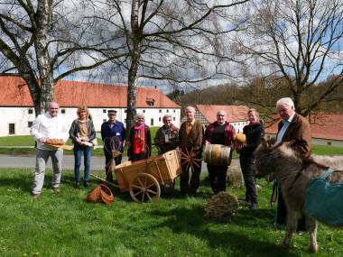 Mit Hand und Herz: Auf den Familientag "Et labora! Handwerk im Kloster" freuen sich (v.l.): Willi Zacharias (Bäckerei), Museumspädagogin Dr. Christiane Wabinski, Burkhard Jüstel (Mühle), Claudia Gensch (Korbflechterei), Roswitha Neumann (Weberei), Franz-Josef Mertens (Stellmacherei), Hermann Zinser (Brennerei), Rita Meermeyer mit Huhn Cordula (Hühnermobil), Erwin Borkenhagen (Norikergestüt Borkenhagen) mit den Eseldamen Lotte und Rosalie (Esel im Altenautal).<br>Foto: LWL/Kristina Schellenberg