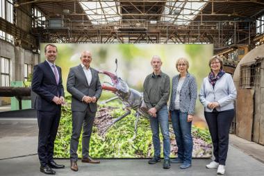 Stefan Ast, Geschäftsführer der NRW-Stiftung, LWL-Direktor Dr. Georg Lunemann, der Fotograf Klaus Rieboldt, die Fotografin Ute Matzkows  und Museumsdirektorin Dr. Kirsten Baumann (v.l.) vor dem Bild eines Hirschkäfers in der Ausstellung "IndustrieInsekten".<br>Foto: LWL / Harms