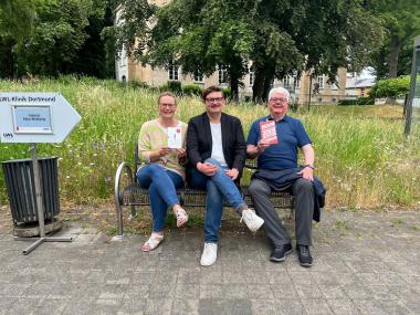 Las in der LWL-Klinik: Peter Wittkamp (Mitte) - hier zusammen mit der Organisatorin und Pressereferentin Angelika Herstell und mit Oberarzt Hans Joachim Thimm, und mit der Taschenbuch- und der Hardcover-Ausgabe von "Für mich soll es Neurosen regnen".<br>Foto: LWL/Wyludda
