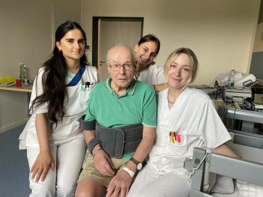 Die Auszubildenden zur Pflegefachfrau, (v.l.) Songül Kardasglu, Rafaela Drosinou und Viktoria Formella, nehmen Patient Ingo Sill in die Mitte. Er ist derzeit auf der Station Innere Medi-zin/Geriatrie des LWL-Klinikums Gütersloh in Behandlung.<br>Foto: LWL/Dresmann