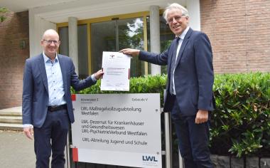 Präsentieren das Zertifikat für einen familienfreundlichen Arbeitgeber: LWL-Maßregelvollzugsdezernent Tilmann Hollweg (l.) und LWL-Krankenhausdezernent Prof. Dr. Meinolf Noeker.<br>Bild: LWL/Forbrig