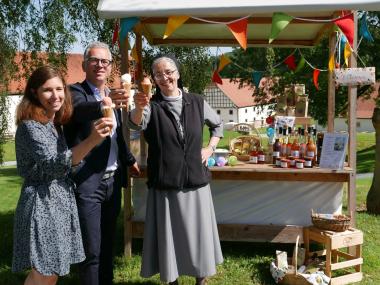 Eis-Zeit im Kloster Dalheim: Organisatorin Eva Beyerstedt, Museumsdirektor Dr. Ingo Grabowsky und Schwester Laetitia von den Schwestern der Hl. Maria Magdalena Postel (v.l.) laden mit süßen Erfrischungen zum Dalheimer Klostermarkt ein.<br>Foto: LWL/Kristina Schellenberg