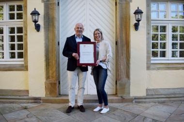 Matthias Grimm, Kaufmännischer Direktor der LWL-Maßregelvollzugskliniken Schloss Haldem und Rheine (l.) und Sina Mailand, Referentin für Personalentwicklung und Audit-Verantwortliche der beiden LWL-Kliniken, mit dem Zertifikat zum "audit berufundfamilie" der gemeinnützigen Hertie-Stiftung.<br>Foto: LWL 