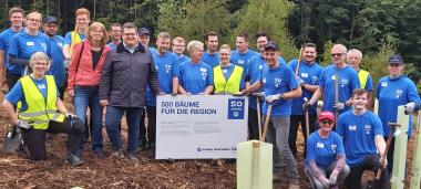 Teamarbeit beim Baumpflanzen: Der Dezernent des LWL-Bau- und Liegenschaftsbetriebes,  Urs Frigger, und die LWL-BLB-Mitarbeiterin Haike Volz mit den Mitarbeitenden der Firma Garant im Lengericher Wald.<br>Bild: LWL 
