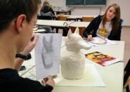Ein Schüler modelliert den Schakal, der dem Totengott Anubis zugeordnet ist.  (vergrößerte Bildansicht wird geöffnet)