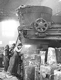 Stahlwerk: Einleitung des Gußvorganges: Kokillen unter dem Ausflusstrichter der Gießpfanne, ca. 1920 / Foto: ©LWL-Medienzentrum für Westfalen/001 Slg. Historische Landeskunde_1/01_3574