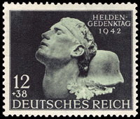 Briefmarkenausgabe Deutsches Reich zum Heldengedenktag 1942, darstellend den Kopf eines Gefallenen und seinen Stahlhelm, 10.03.1942 / Quelle: Wikimedia Commons PD / Michel Junior-Katalog 1999. Deutsches Reich […], München 1997, S. 56 (Nr. 812)