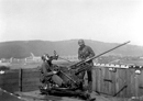 Zwei 16-jährige Luftwaffenhelfer an einem 2-cm-Flakgeschütz am Hengsteysee in Hagen. Rechts im Hintergrund das Laufwasserkraftwerk; das Koepchen-Pumpspeicherkraftwerk ist getarnt im linken Bildhintergrund schemenhaft sichtbar / Hagen, Historisches Centrum