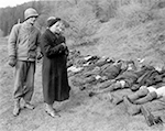 US-Soldat der 95. Infanterie-Division, XVI Corps, mit zwei deutschen Frauen vor den aufgereihten ermordeten Zwangsarbeitern im Warsteiner Langenbachtal. Fototext: "A U.S. Ninth Army soldier conducts two German women past the row of corpses to show them the work of their SS troopers. The corpses are those of 71 Russians, including about 50 women, who are said to have been murdered and than buried in mass graves. American Military authorities ordered German civilians to march past bodies of atrocity victims, which appeared to have been beaten with heavy instruments, and then the bodies will bei buried in individual graves." Freigabe durch den Field Press Censor am 05.05.1945. / NARA, Washington