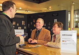 Besucher am Verleihtresen der Audioguides.