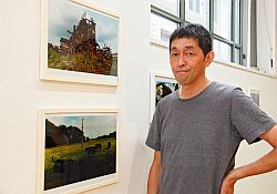 Koji Onaka vor seinen Fotografien.